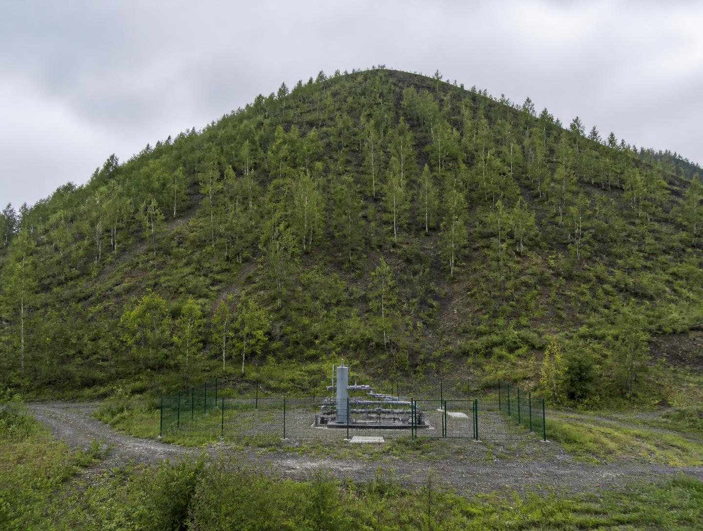 Terril végétalisé du bassin minier des Hauts-de-France avec une tête de puits de captage de gaz de mine à sa base