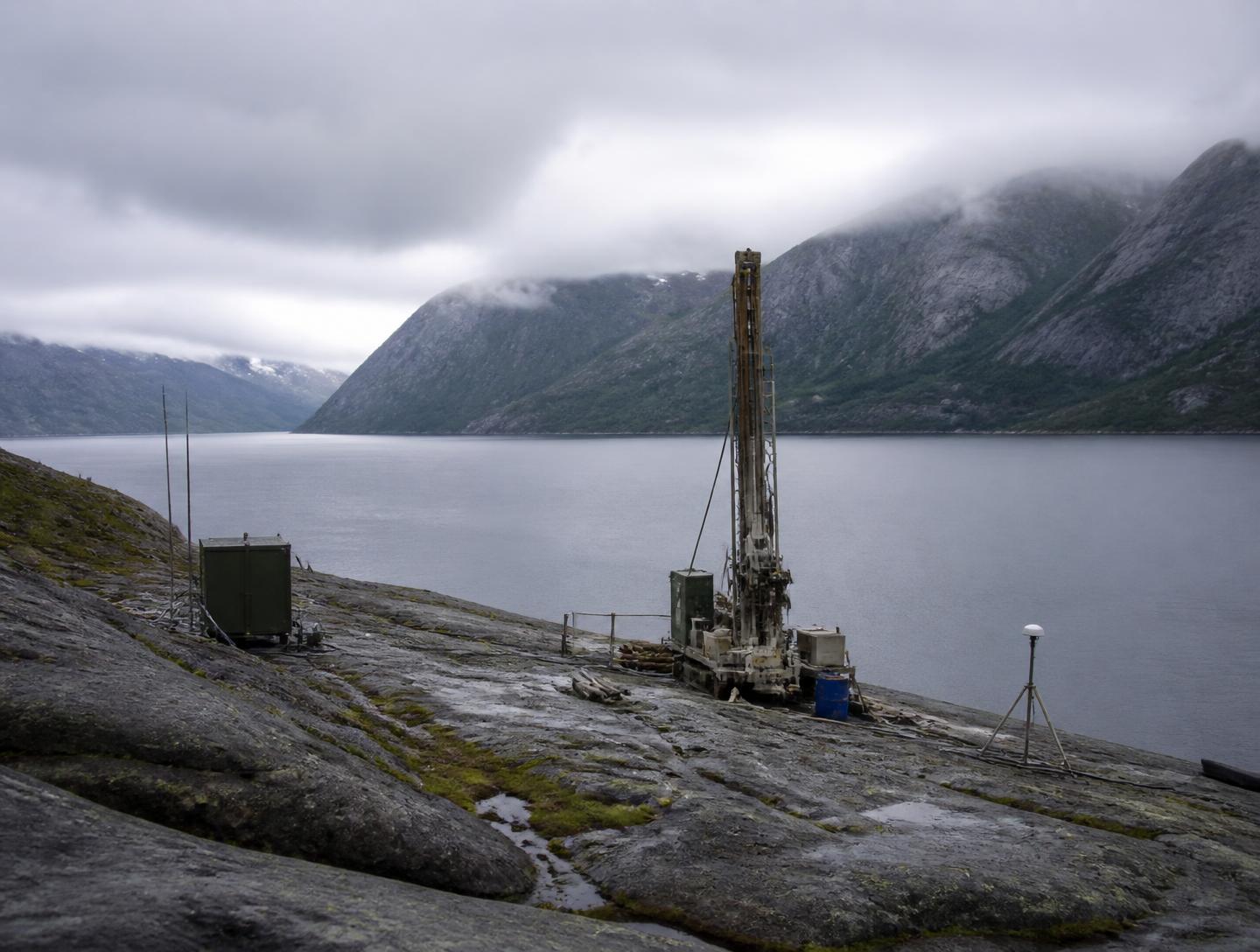 Installation de forage d'évaluation sur roche nue au bord d'un fjord norvégien sous ciel couvert